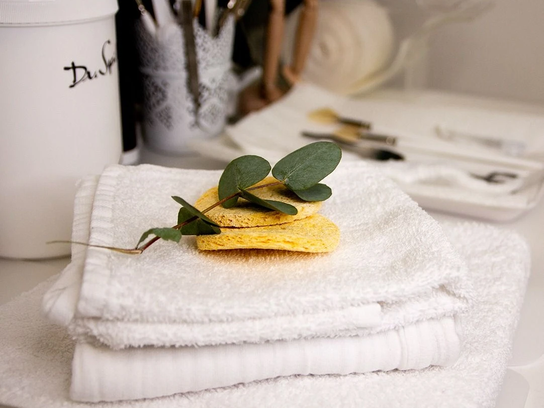 Beauty am Tivoli Handtücher mit Eukalyptusblättern und Schwämmen.
