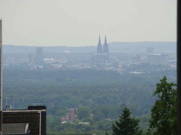 Kölnblick von Schloss Bensberg Blick über bewaldete Landschaft auf die entfernte Skyline von Köln, mit dem Kölner Dom im Zentrum.