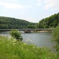 Vorsperre der Wuppertalsperre <p>Eine Brücke überspannt einen ruhigen Fluss, umgeben von üppiger grüner Vegetation.</p>