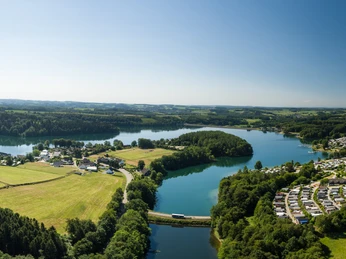 Bevertalsperre von oben Luftaufnahme einer Landschaft mit zwei Seen, umgeben von Wäldern und Dörfern unter klarem Himmel.