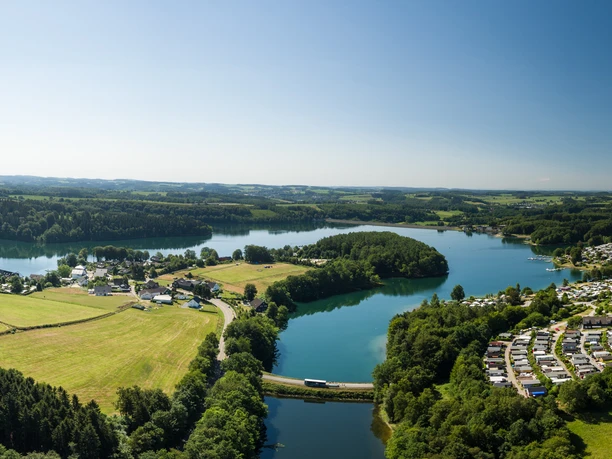 Bevertalsperre von oben Luftaufnahme einer Landschaft mit zwei Seen, umgeben von Wäldern und Dörfern unter klarem Himmel.