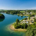 <p>Luftaufnahme von Hückeswagen mit Blick auf eine von Wald umgebene Seelandschaft und Campingplatz.</p>