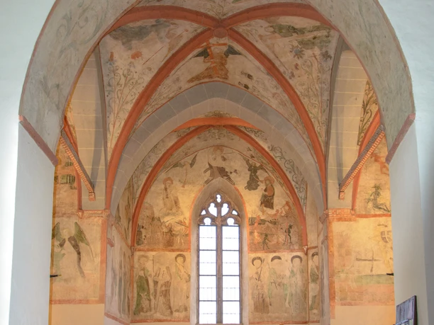Innenansicht Gotische Kapelle mit Fresken und bemalten Gewölben. Altar mit modernen und historischen Elementen.