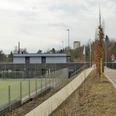 Mediendatei Ein Sportplatz mit Toren und Nebenplatz, gesäumt von Bäumen entlang eines angrenzenden Weges.