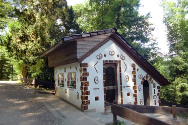 Märchenwald Altenberg Kleines, märchenhaftes Hexenhäuschen im Wald, dekoriert mit Pfefferkuchen und Brezeln.