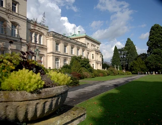 Villa Hügel Historisches Gebäude im viktorianischen Stil, umgeben von gepflegtem Garten und üppiger Vegetation.