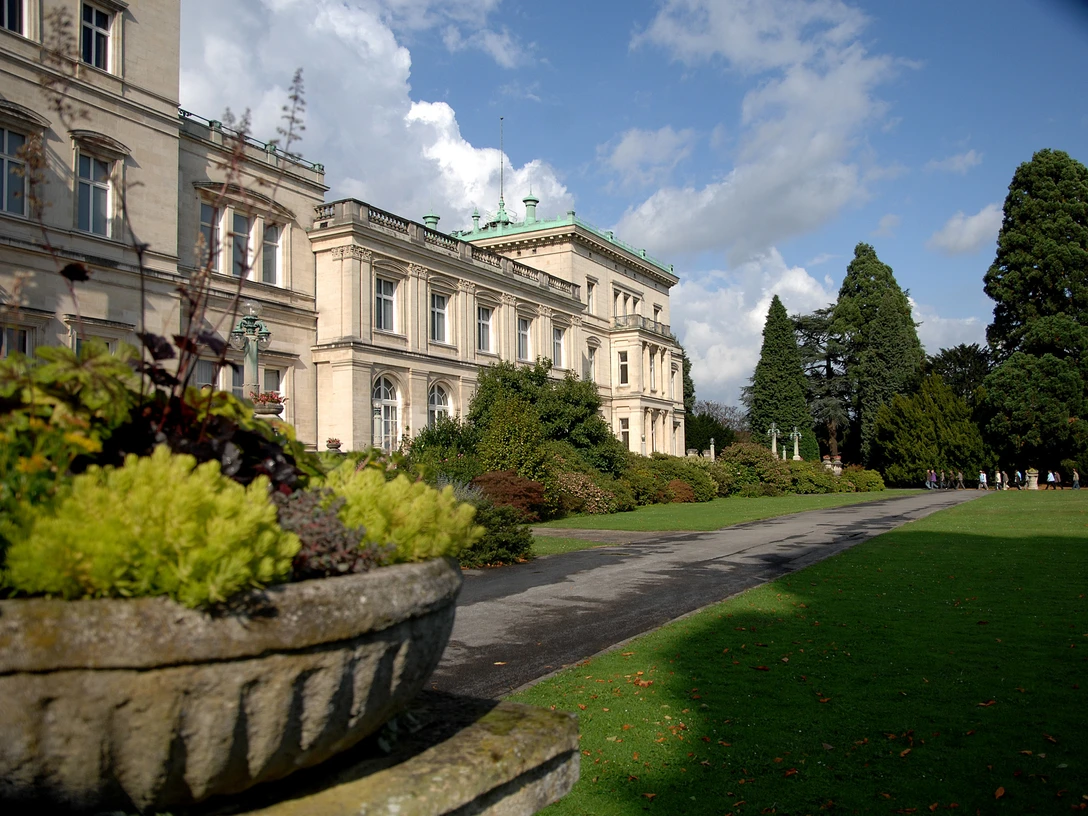 Villa Hügel Historisches Gebäude im viktorianischen Stil, umgeben von gepflegtem Garten und üppiger Vegetation.