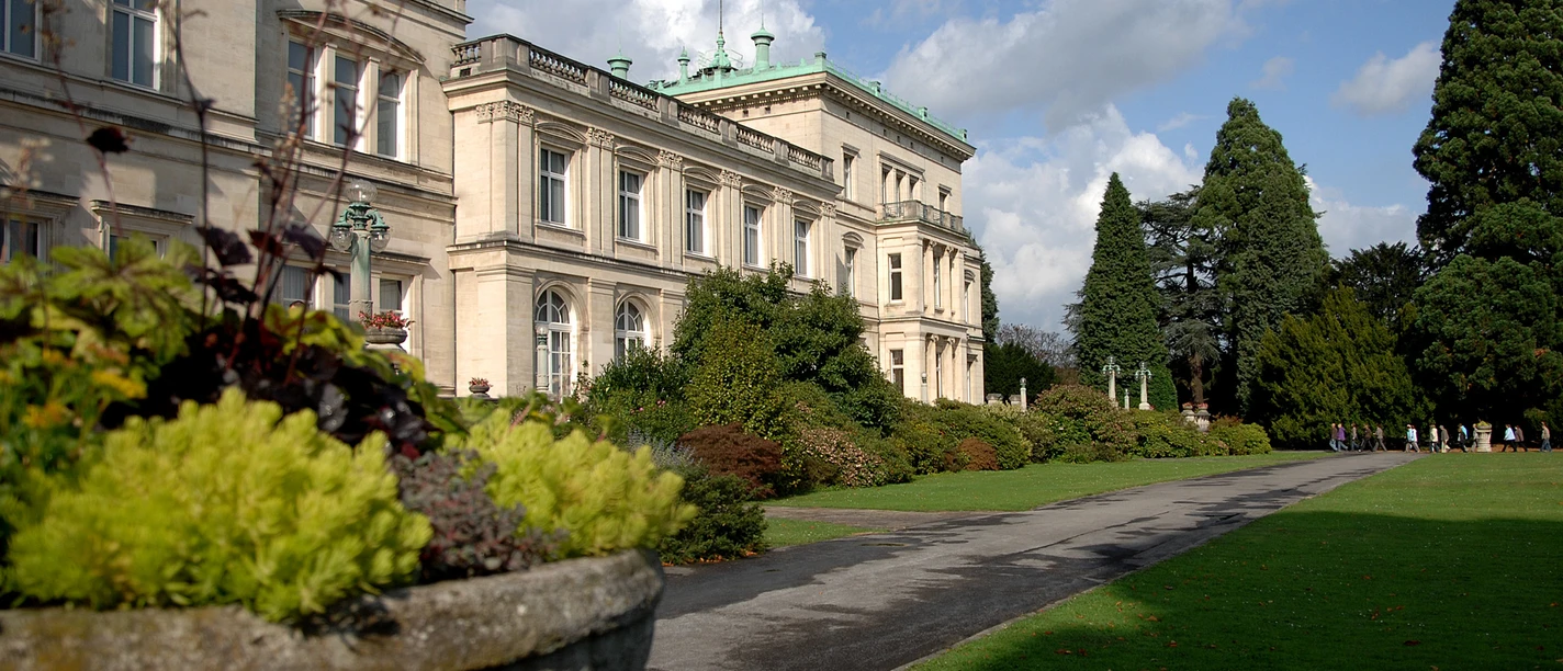 Villa Hügel Historisches Gebäude im viktorianischen Stil, umgeben von gepflegtem Garten und üppiger Vegetation.