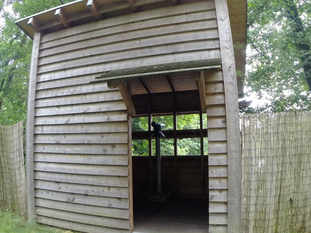 Vogelbeobachtungsstation an der Wupper Holzhütte mit schrägem Dach im Wald, offener Eingang auf grüner Wiese, Weg aus Metallplatten.