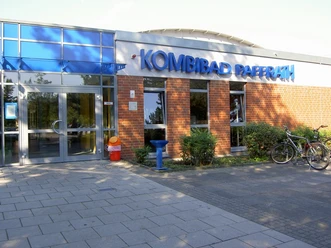 Kombibad Paffrath Das Bild zeigt den Eingang des Kombibads Paffrath mit blauen Fenstern und Ziegelwänden.