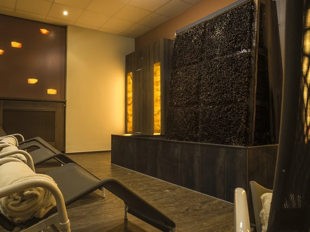 life-ness Ruheraum Ein eleganter Wellnessbereich mit Relaxliegen, sanfter Beleuchtung und einem vertikalen Wasserfall.