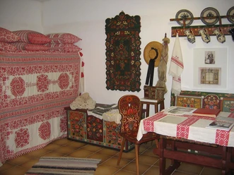 Mediendatei Ein traditionell eingerichtetes Zimmer mit handgefertigten Textilien und folkloristischer Dekoration.