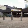 Quellenbad Wermelskirchen Eingangsbereich eines modernen Hallenbads mit Cafeteria, Betongebäude, Pflanzenarrangements.