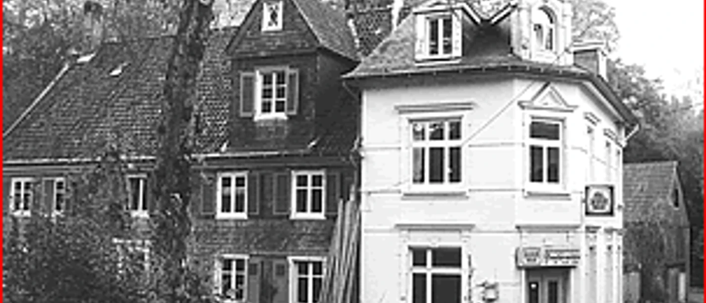 Mediendatei Historisches, zweigeschossiges Gebäude mit Fachwerk und Satteldach in ländlicher Umgebung.