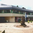 Bürgerhaus Radevormwald Mehrstöckiger Brunnen aus Bronzegussscheiben auf gepflastertem Platz vor einem modernen Gebäude.