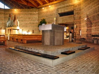 Bonifatiuskirche in Wildbergerhütte Ein hölzerner Innenraum mit Altar, Orgel und Bänken einer modernen Kirche mit Ziegeldesign.