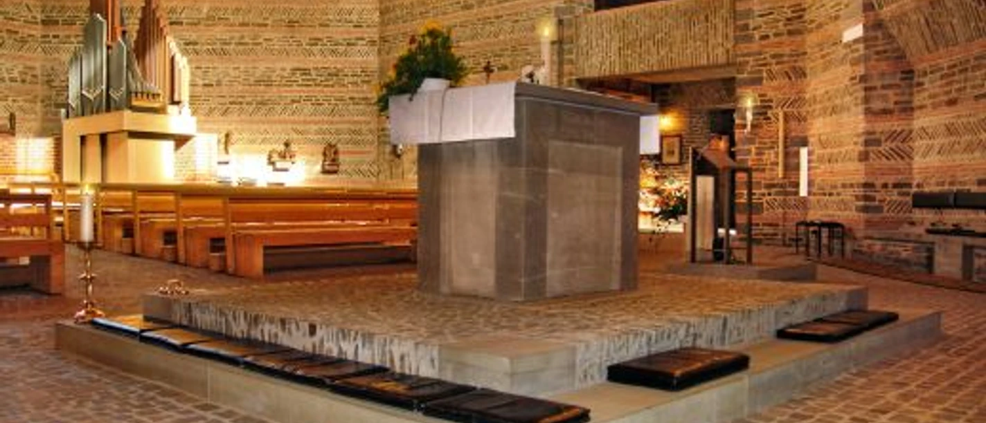 Bonifatiuskirche in Wildbergerhütte Ein hölzerner Innenraum mit Altar, Orgel und Bänken einer modernen Kirche mit Ziegeldesign.