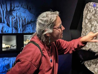 Besucherin an der Goniatitenwand Eingangsraum zu Höhle und archäologischem Museum HEZ Besucherin an der Goniatitenwand Eingangsraum zu Höhle und archäologischem Museum HEZ
