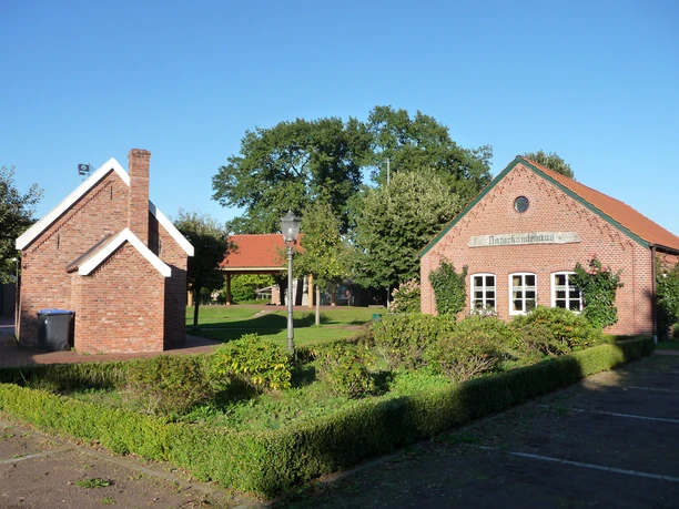 Heimathaus Dörpen Backsteingebäude mit rotem Dach und gepflegtem Garten im Heimathaus Dörpen bei blauem Himmel