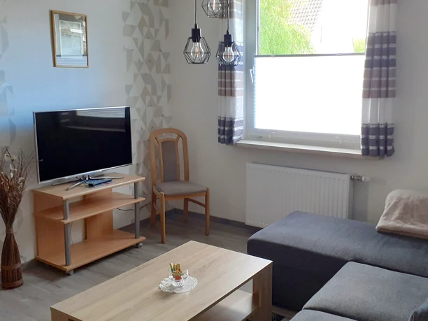 Woonkamer met toegang tot de serre van de vakantiewoning Pülsch