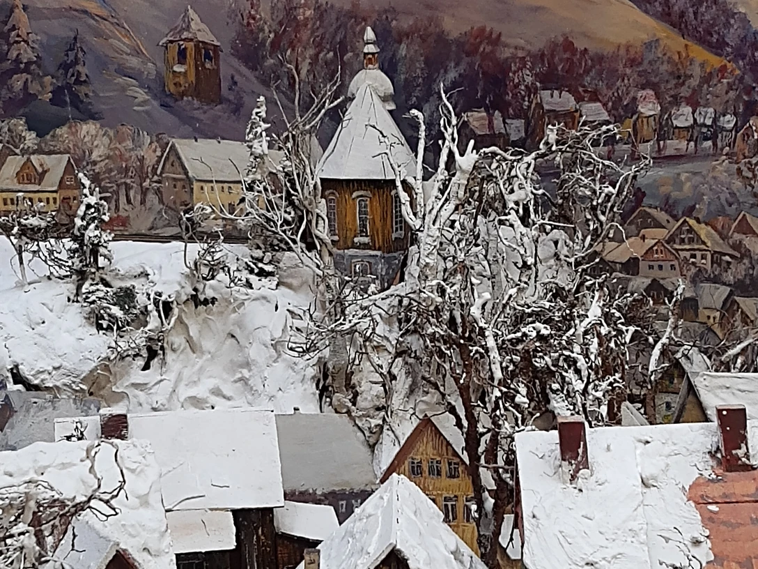 Bild einer Winterlandschaft mit Holzkirche.
