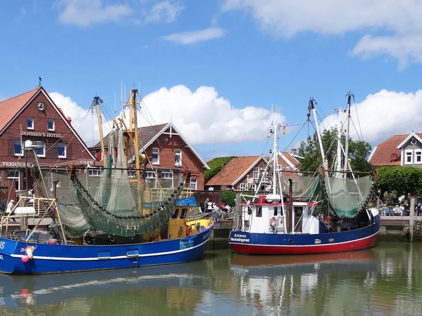 neuharlingersiel Hafen von Neuharlingersiel mit bunten Fischerbooten und traditioneller Backsteinarchitektur im Hintergrund.