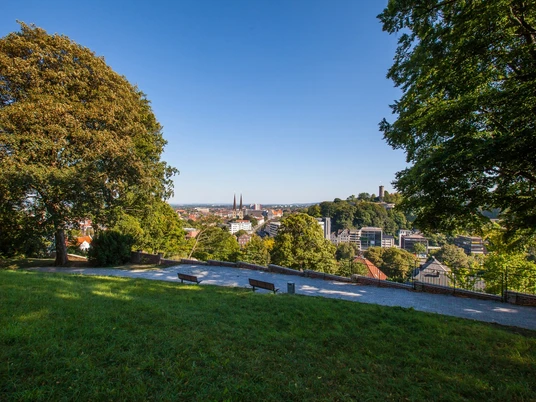 Johannisberg Bielefeld Panoramablick auf die Stadt mit grüner Parkfläche im Vordergrund und historischer Architektur.