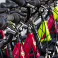 Fahrradverleih Mehrere Fahrräder stehen nebeneinander gereiht, in den Farben rot, gelb und weiß
