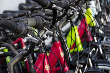 Radsport Mehrere farbige Fahrräder stehen eng nebeneinander, mit Griffen und Bremshebeln in der Nahaufnahme.