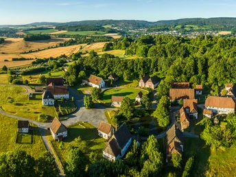 Detmold-2023-021-LWL Freilichtmuseum-Teutoburger-Wald-Tourismus-D-Ketz.jpg Luftaufnahme des Freilichtmuseums Detmold, umgeben von Feldern und Wäldern in der Morgensonne.