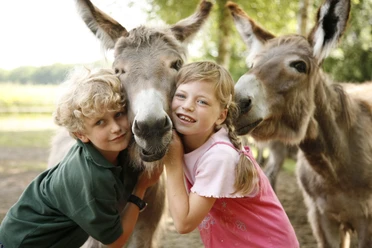 Zwei Kinder mit Eseln im LandPark Lauenbrück Zwei Kinder mit Eseln im LandPark Lauenbrück