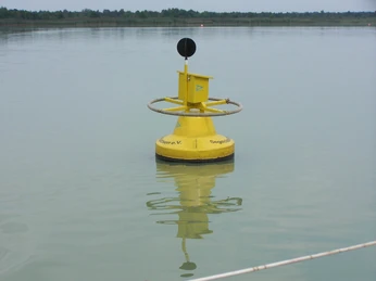 Gelbe Boje im Steinhuder Meer, von Wasser umgeben, trägt ein Schild und reflektiert sich im ruhigen See.