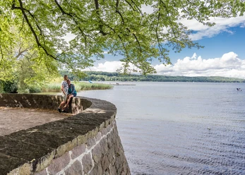 Aussicht vom Barlachblick in Ratzeburg Ein Paar steht auf dem Wall und blickt auf den See