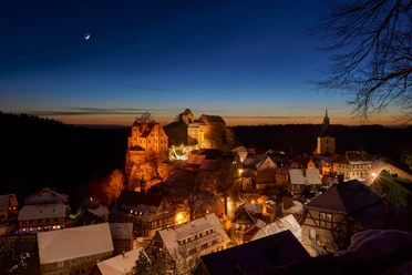 Burg Hohnstein im Winter Burg Hohnstein thront im winterlichen Abendlicht über dem verschneiten, festlich beleuchteten Ort.