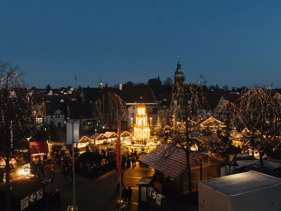 Weihnachtsmarkt in Bad Salzuflen bei Abenddämmerung, leuchtende Buden und Menschenansammlung.