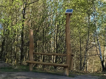 Hörstation am Lönsstein in Oerlinghausen Eine hölzerne Hörstation mit Solarpanel in einem waldreichen Gebiet unter Bäumen am Lönsstein.