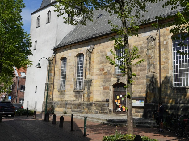 Evangelisch-reformierte Kirche in Lingen Sandstein-Kirchbau mit hohen Rundbogenfenstern und weißem Turm an einer ruhigen Straße in Lingen