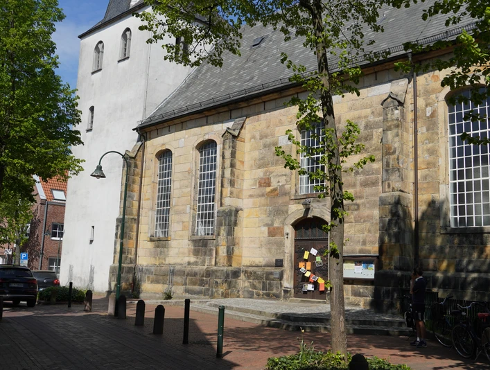 Evangelisch-reformierte Kirche in Lingen Sandstein-Kirchbau mit hohen Rundbogenfenstern und weißem Turm an einer ruhigen Straße in Lingen