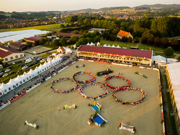 Hof Kasselmann paardensport in Hagen a.T.W. in het Osnabrücker Land Luftaufnahme eines Pferdeparcours mit Menschen, die olympische Ringe im Sand formen.