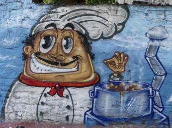 Graffiti eines fröhlichen Kochs mit erhobenem Daumen neben einem dampfenden Suppentopf.