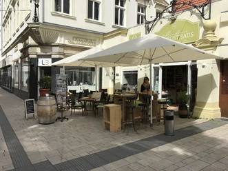 Mindener Feinkosthaus Das Bild zeigt den Außenbereich und Sitzmöglichkeiten des Mindener Feinkosthauses
