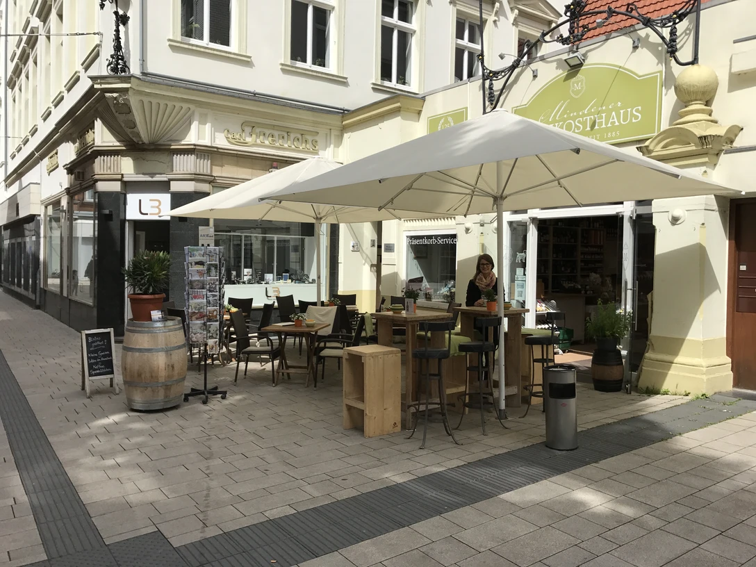 Mindener Feinkosthaus Das Bild zeigt den Außenbereich und Sitzmöglichkeiten des Mindener Feinkosthauses