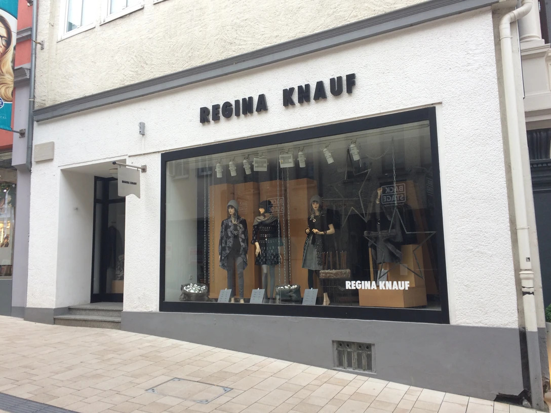 Modegeschäft von Regina Knauf mit großer Schaufensterfront in einer Fußgängerzone.