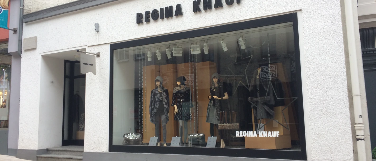 Modegeschäft von Regina Knauf mit großer Schaufensterfront in einer Fußgängerzone.
