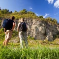 Wellenkalk am Prallhang Schwiemelkopf Zwei Wanderer betrachten eine beeindruckende Steilwand aus Wellenkalk unter einem klaren Himmel.