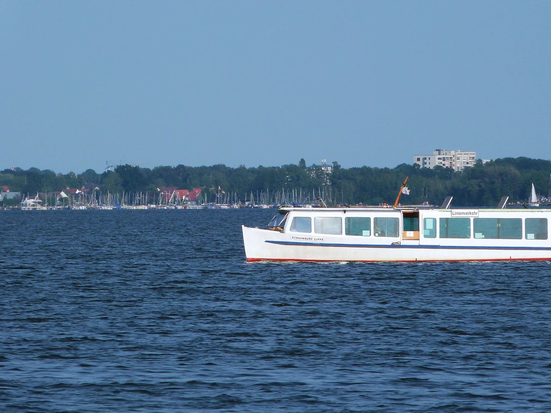 Schaumburg-Lippe auf dem Steinhuder Meer Ein weißes Passagierschiff fährt auf dem ruhigen Steinhuder Meer entlang, im Hintergrund Segelboote.A white passenger ship sails along the calm Steinhuder Meer with sailing boats in the background.Et hvidt passagerskib sejler langs det rolige Steinhuder Meer med sejlbåde i baggrunden.Een wit passagiersschip vaart over het rustige Steinhuder Meer met zeilboten op de achtergrond.