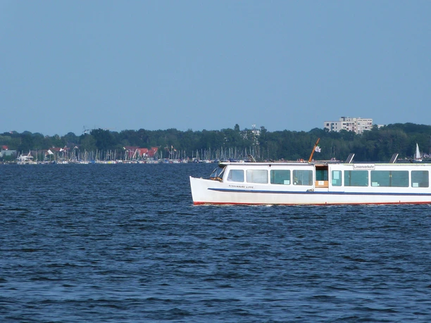 Schaumburg-Lippe auf dem Steinhuder Meer Ein weißes Passagierschiff fährt auf dem ruhigen Steinhuder Meer entlang, im Hintergrund Segelboote.
