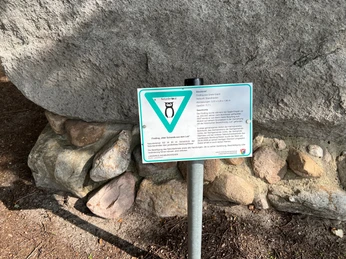 Findling auf steinernem Sockel mit Hinweistafel über die historische Bedeutung des Findlings.