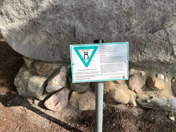 Findling "Alter Schwede aus dem Luk" Findling auf steinernem Sockel mit Hinweistafel über die historische Bedeutung des Findlings.