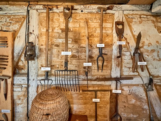 Gärtnermuseum Wolfenbüttel Alte Gartengeräte hängen an Fachwerk-Ziegelwand